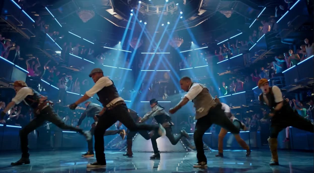 Choreographed performers under blue stage lights